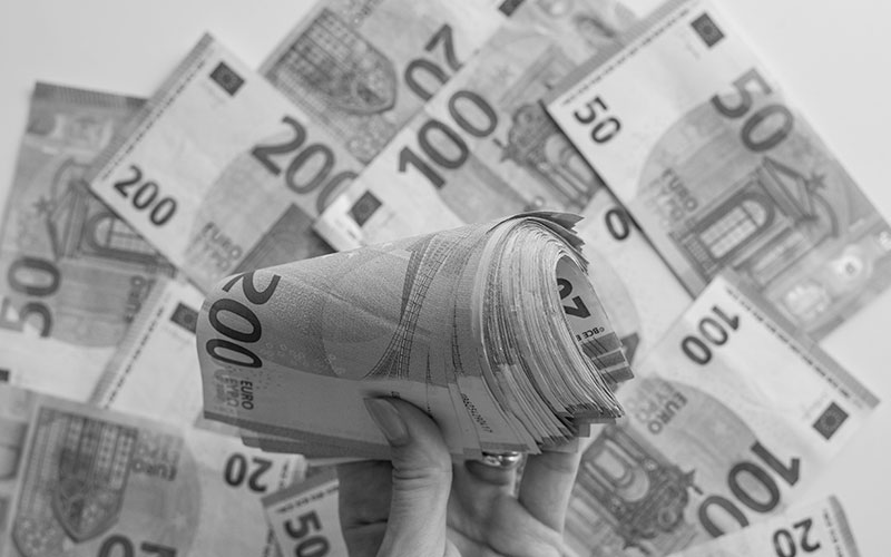 Closeup of a person's hand displaying an abundance of money.
