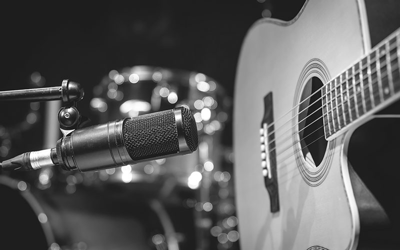 Acoustic guitar and microphone, recording in a music studio.
