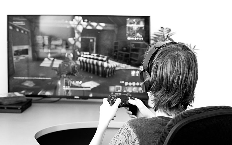 Teenager or young men play online video game. Gaming. Unrecognisable Gamer from back with joystick